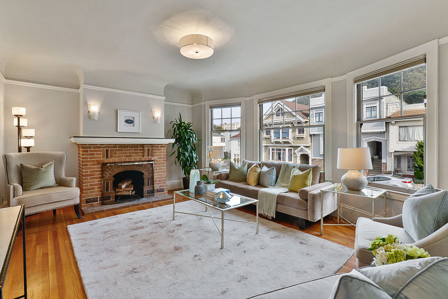 Property Photo: View of the living room, featuring a brick fireplace and large windows
