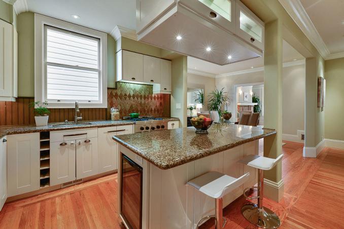Property Thumbnail: Kitchen with wood floors and an island with seating 