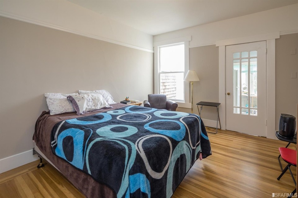 Property Photo: A bedroom with wood floors and exterior door