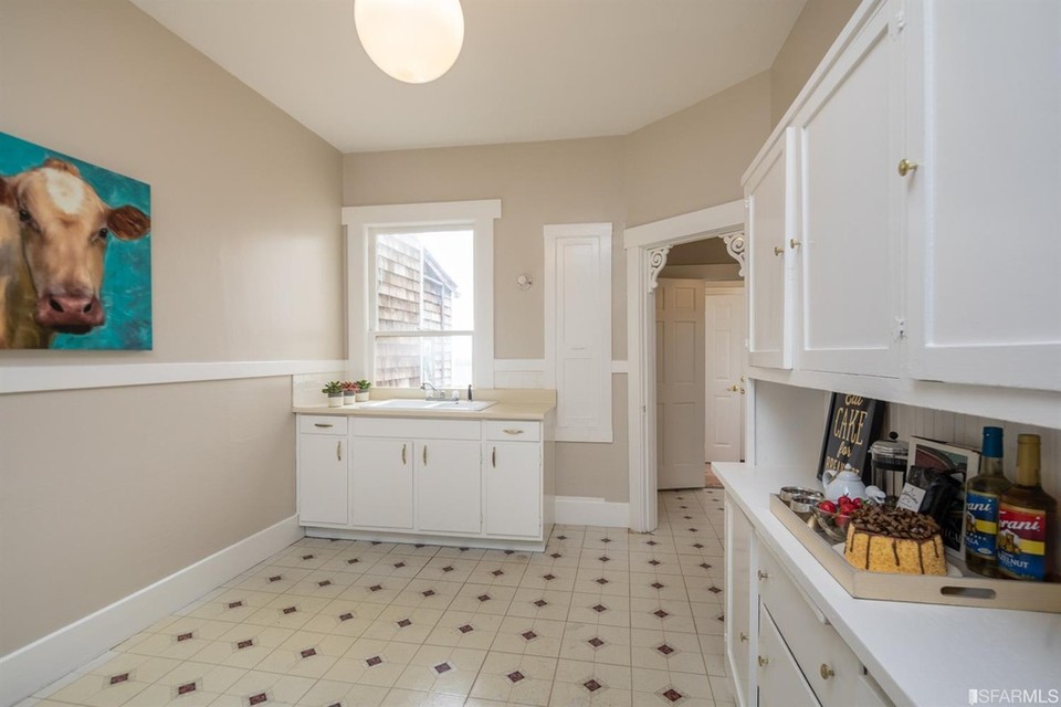 Property Photo: View of the kitchen, featuring white cabinets