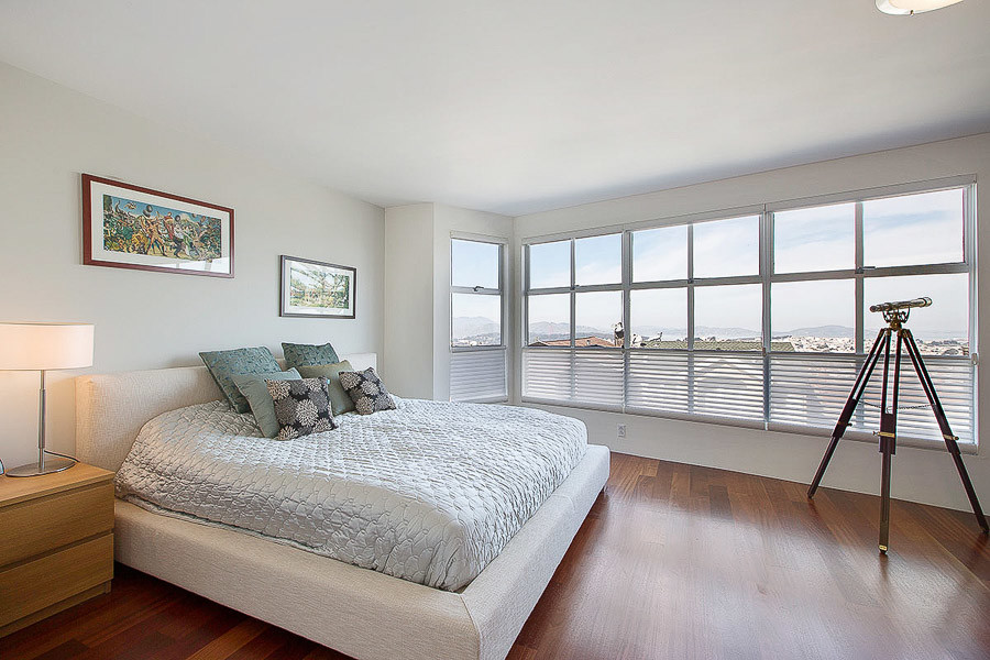 Property Photo: View of a large bedroom with wood floors and wall-to-wall windows