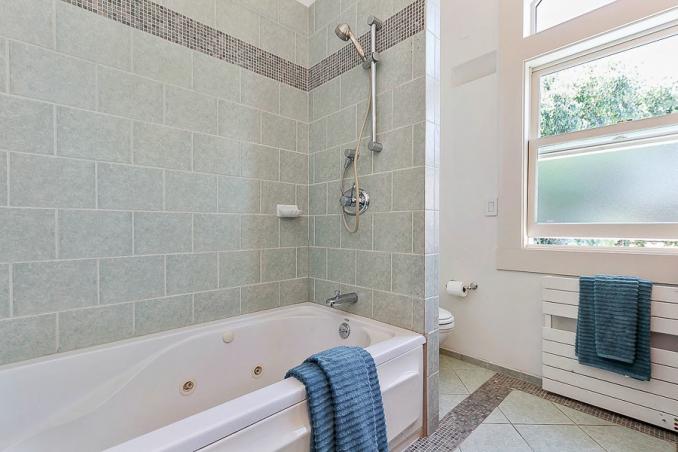 Property Thumbnail: Bathroom with green/gray tiling 