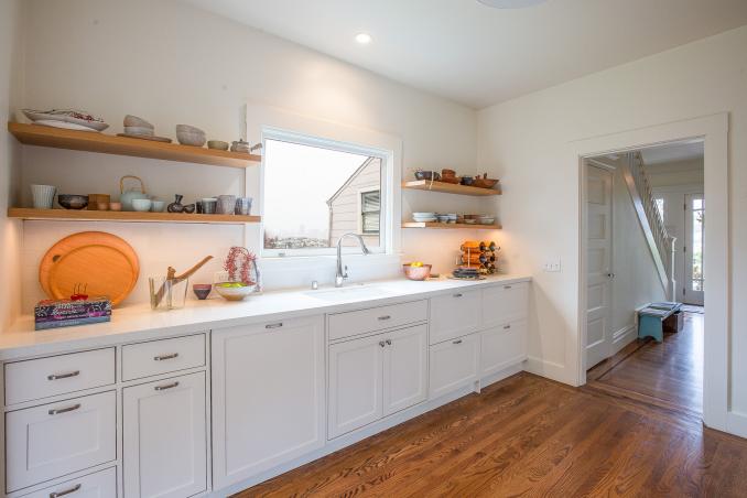 Property Thumbnail: Close-up view of the white cabinets and open shelves in the kitchen