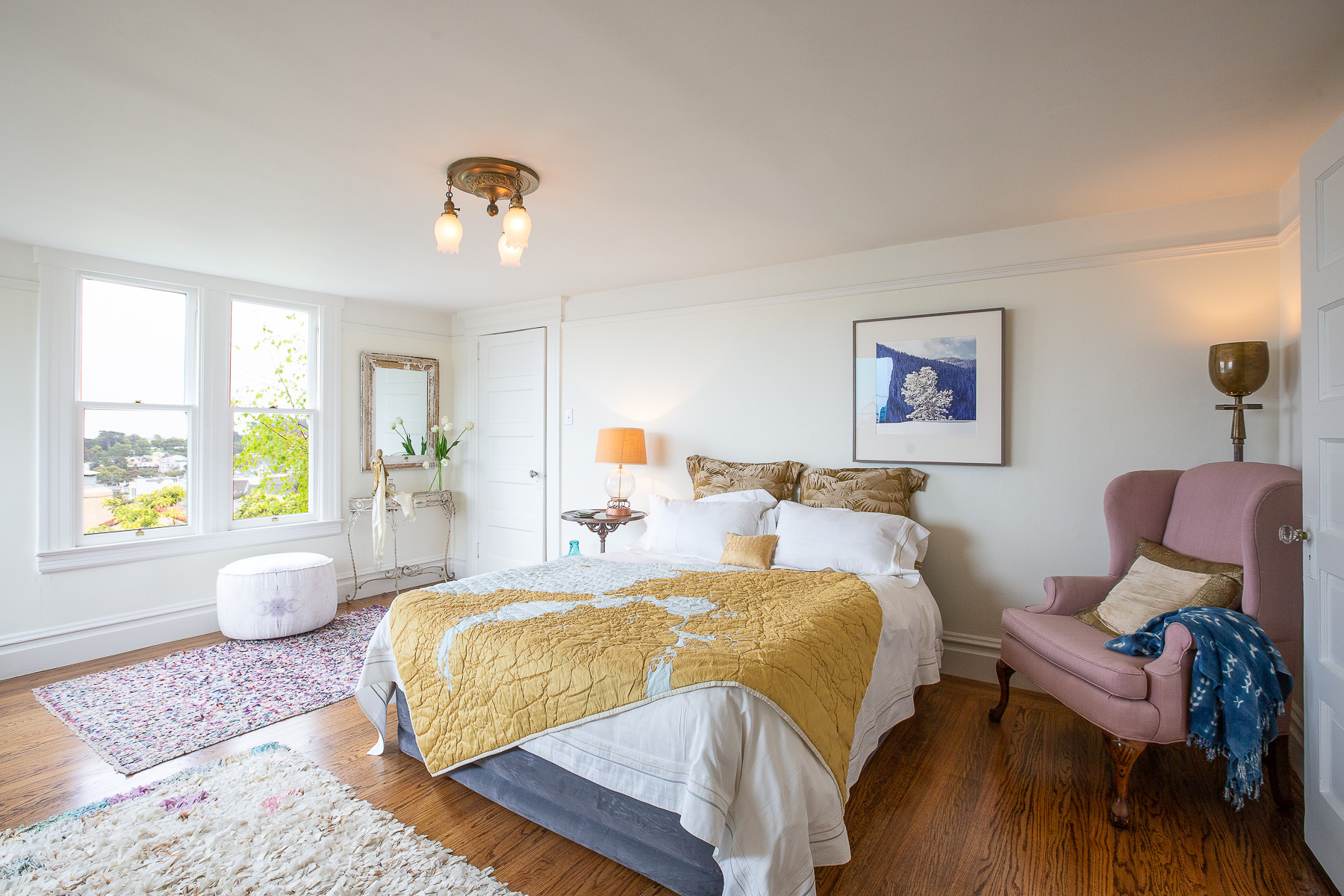 Property Photo: Bedroom with large windows and wood floor