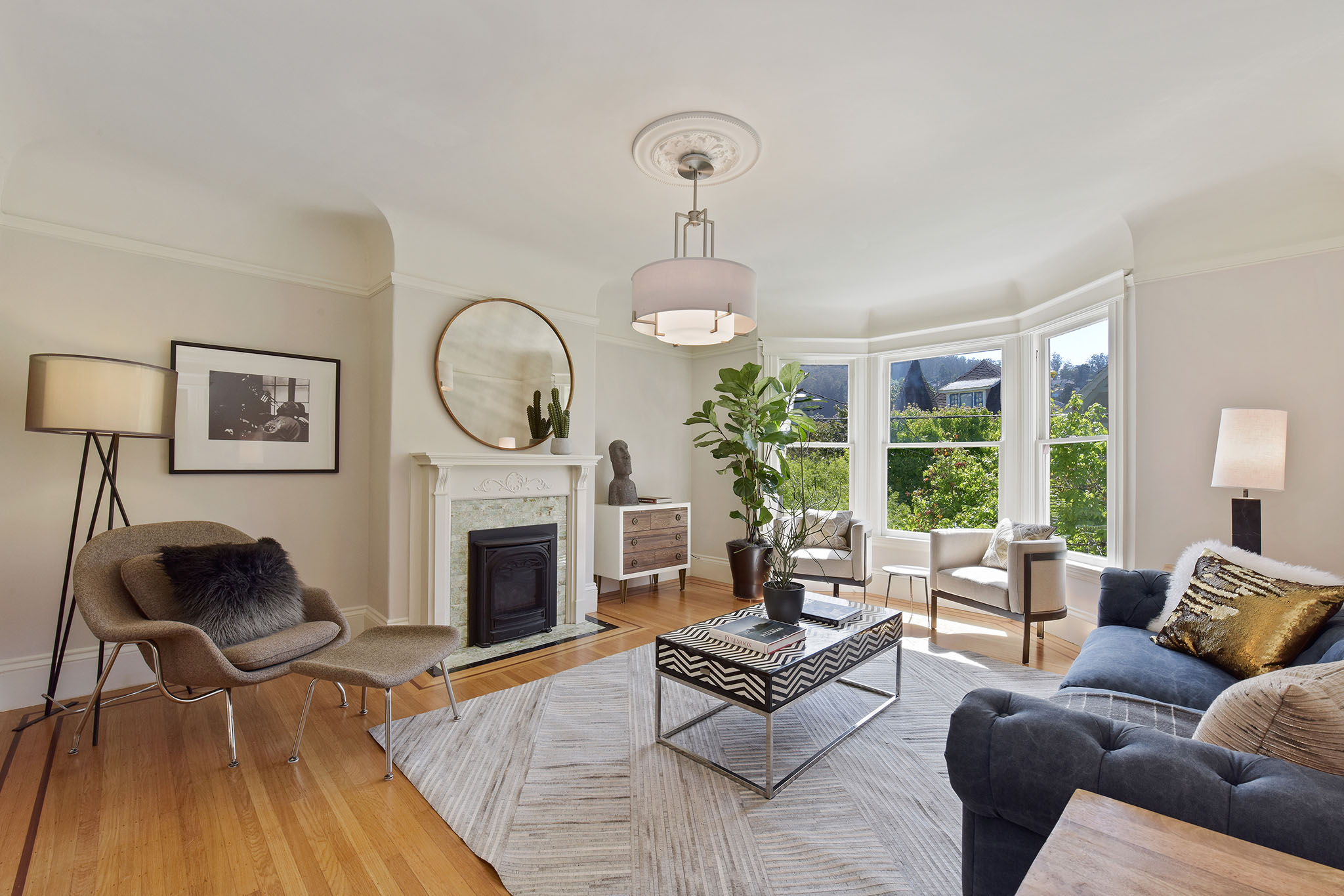 Property Photo: Living room, showing a fireplace with white mantle and bay windows