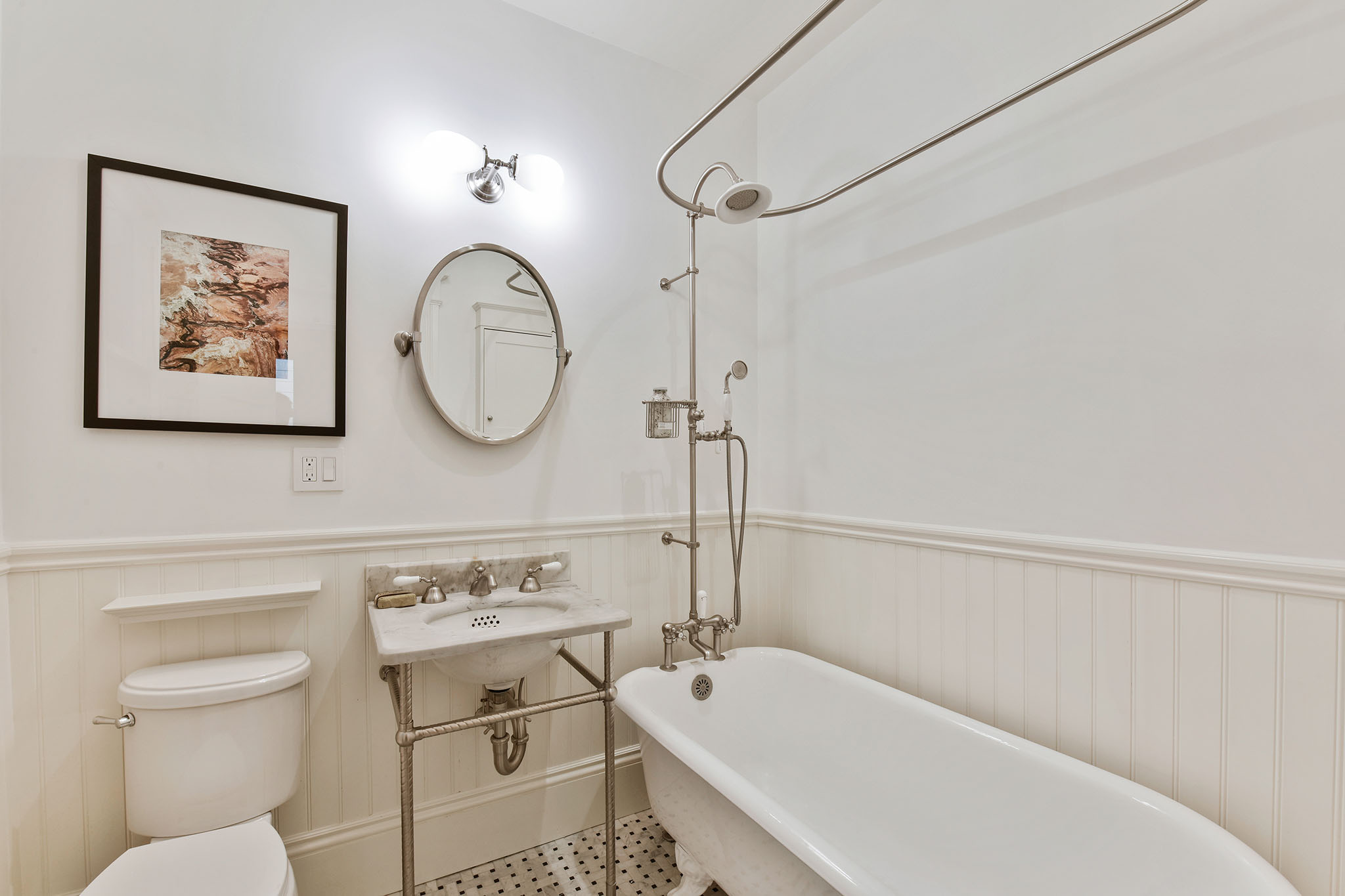 Property Photo: Bathroom with free-standing bath tub and white wainscoting