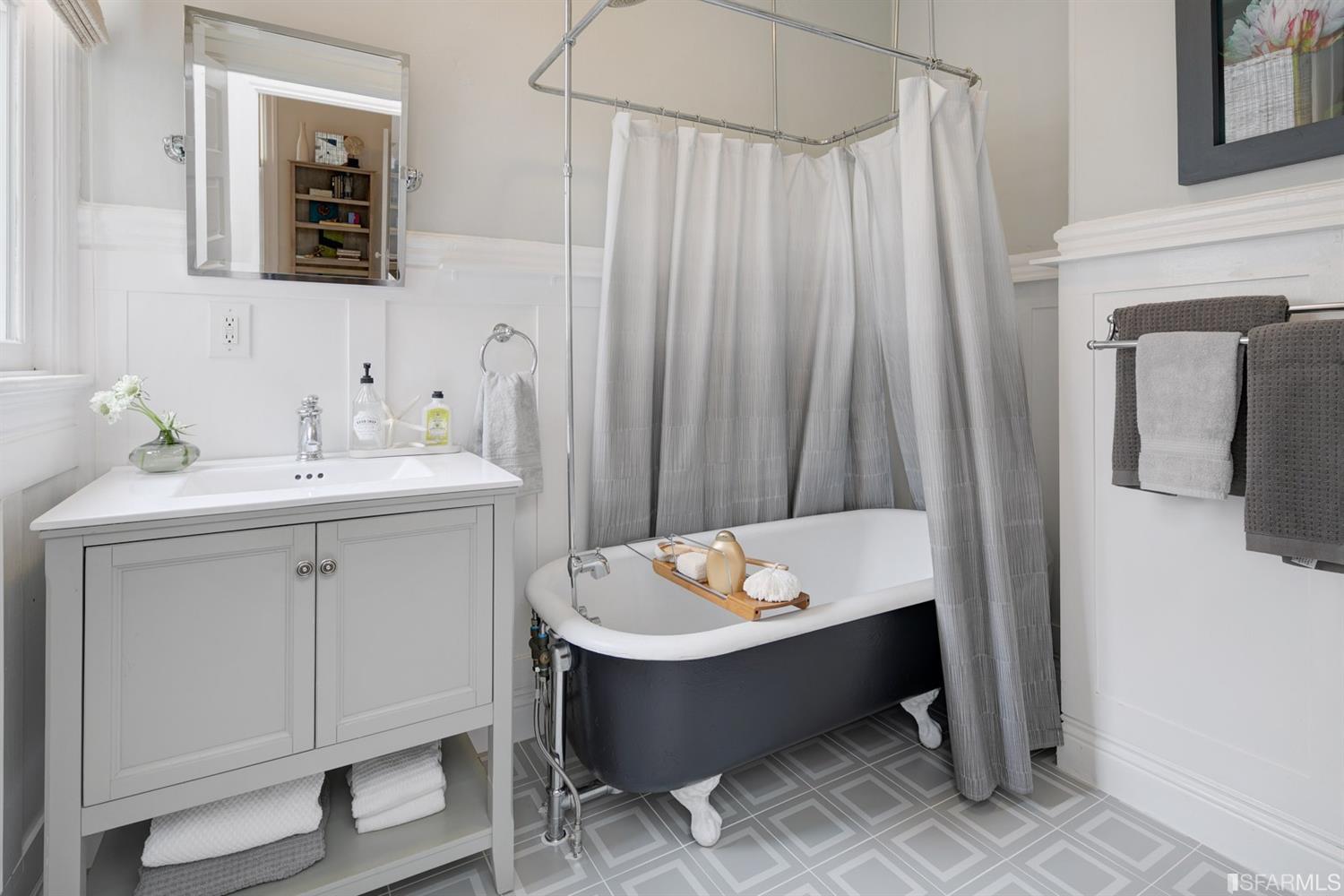 Property Photo: Bathroom with free-standing bath tub and white wainscoting