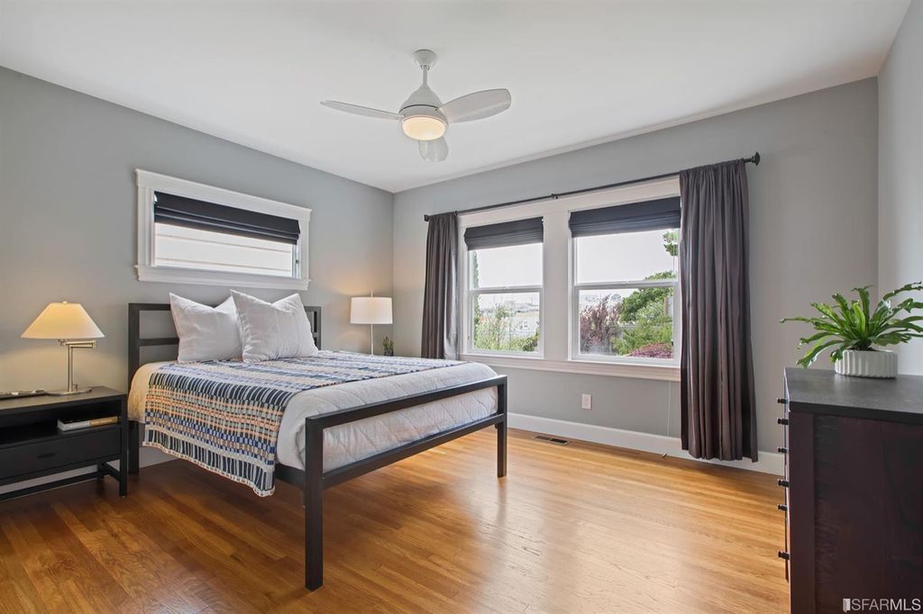 Property Photo: View of a bedroom with wood floors and large windows 
