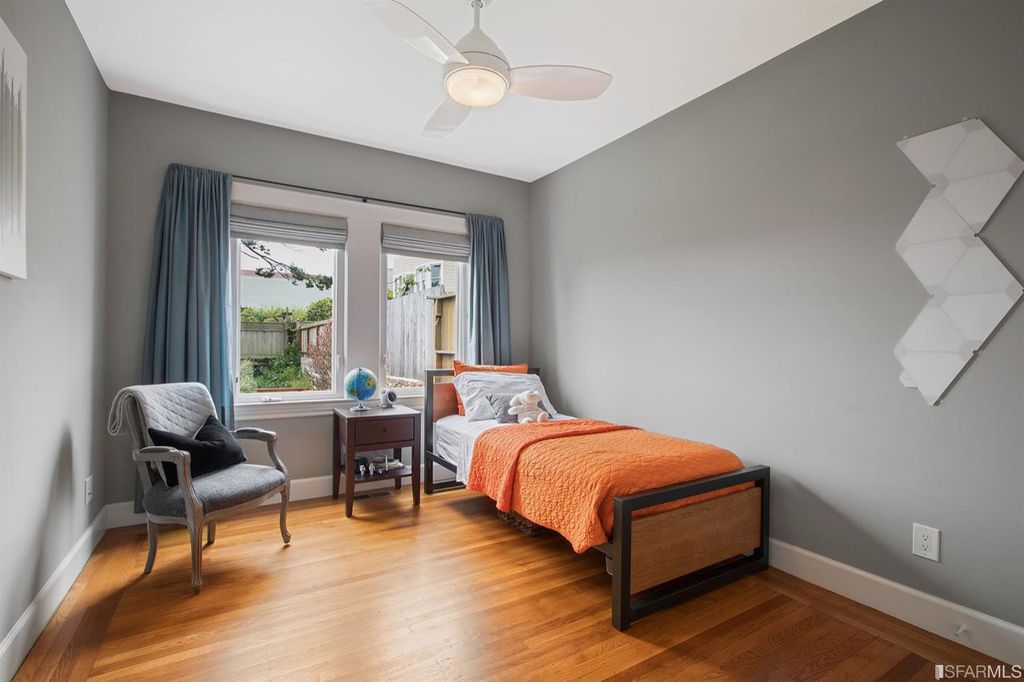 Property Photo: View of another bedroom with two large windows and wood floors